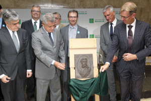 Rollemberg olha para a placa de bronze em homenagem a Luiz Cruls. O prefeito de Diest, na Bélgica, está tirando o pano que cobria a placa.