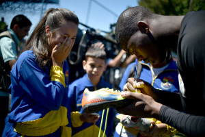 O goleiro da seleção olímpica da África do Sul, Nkosingiphile Gumede, autografa um chuteira para alunos do Colégio Militar Tiradentes.