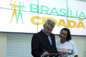 O governador Rodrigo Rollemberg, acompanhado da esposa e colaboradora do governo, Márcia Rollemberg, assina o decreto.